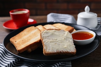 Photo of Slices of tasty toasted bread with butter and jam on wooden table, closeup