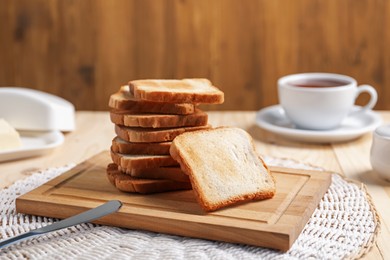 Photo of Slices of tasty toasted bread on wooden table, closeup