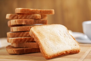 Photo of Slices of tasty toasted bread on wooden board, closeup