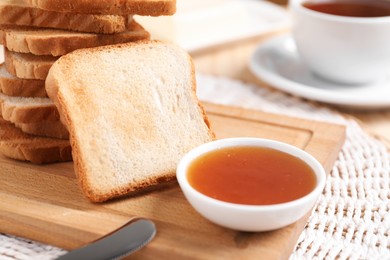 Photo of Slices of tasty toasted bread and jam on table, closeup