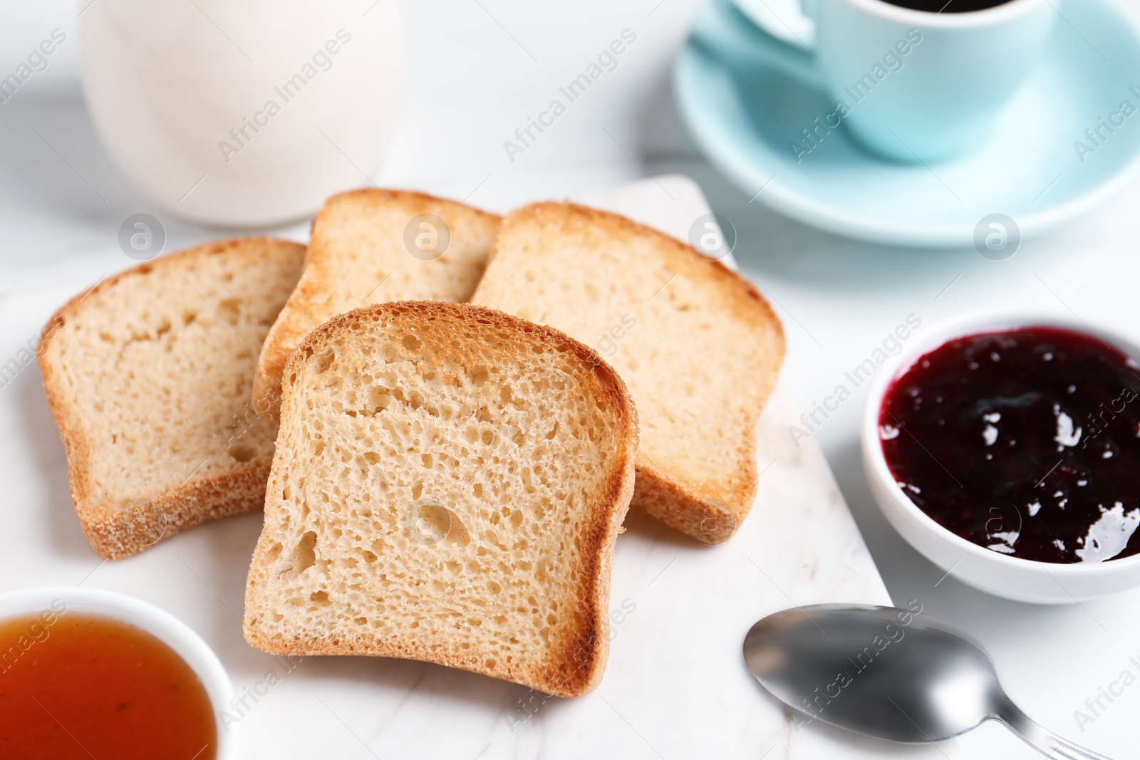 Slices of tasty toasted bread and jam on white table Photo of Slices of tasty toasted bread and jam on white table