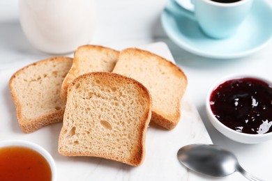 Photo of Slices of tasty toasted bread and jam on white table