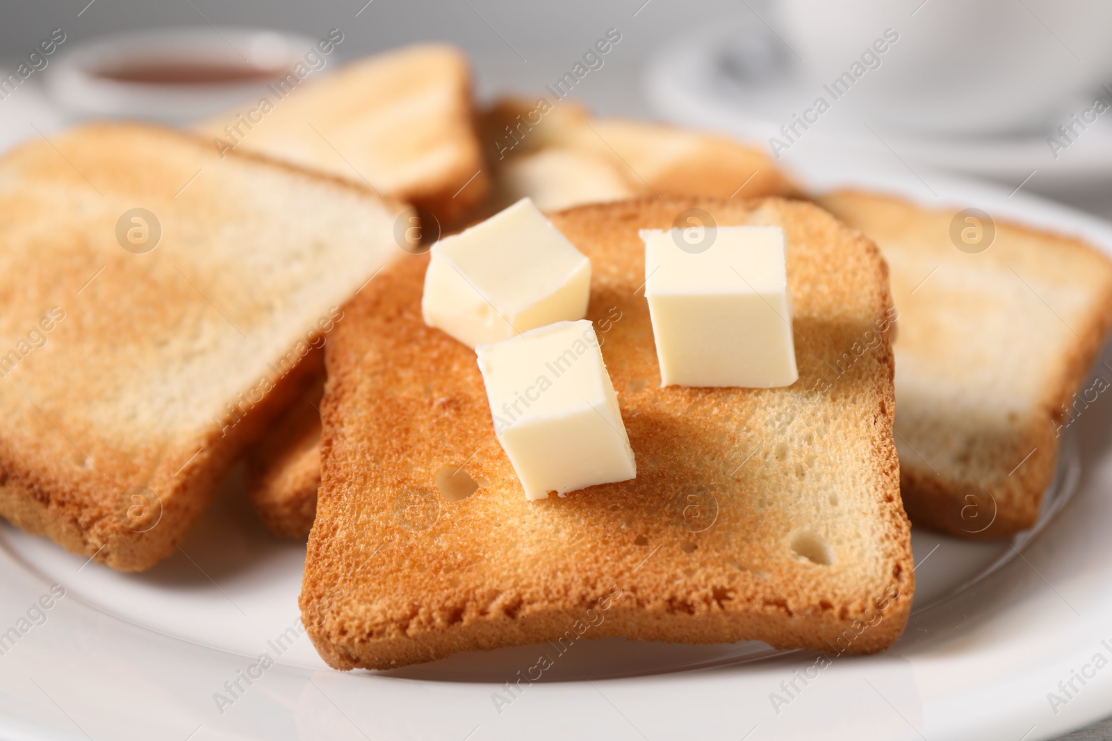 Slices of tasty toasted bread with butter on plate, closeup Photo of Slices of tasty toasted bread with butter on plate, closeup