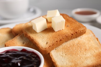 Photo of Slices of tasty toasted bread with butter and jam on table, closeup