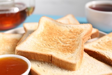 Photo of Slices of tasty toasted bread and jam on blurred background, closeup