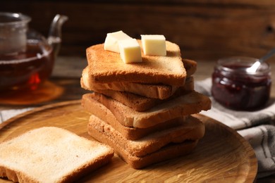 Photo of Slices of tasty toasted bread with butter on table, closeup