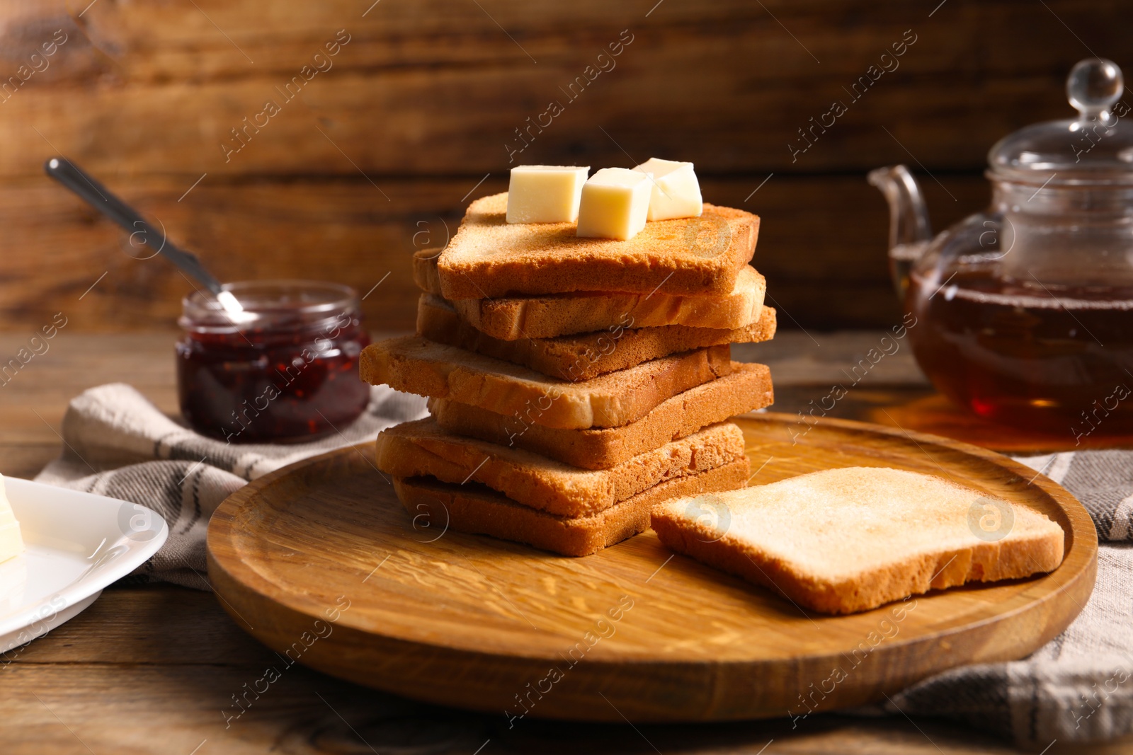 Slices of tasty toasted bread with butter on wooden table, closeup Photo of Slices of tasty toasted bread with butter on wooden table, closeup