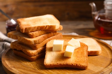 Photo of Slices of tasty toasted bread with butter on table, closeup