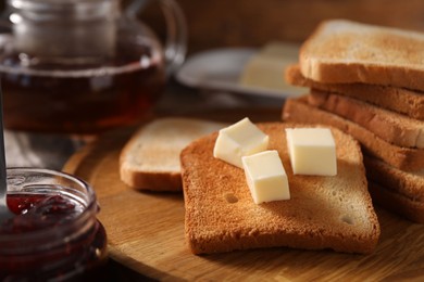 Photo of Slices of tasty toasted bread with butter and jam on table, closeup