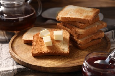 Photo of Slices of tasty toasted bread with butter and jam on table, closeup