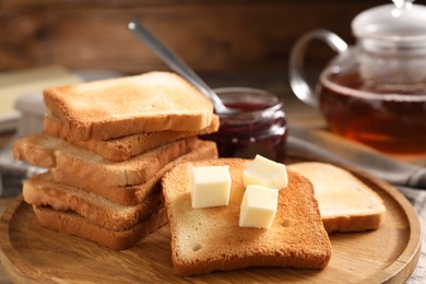 Photo of Slices of tasty toasted bread with butter on table, closeup