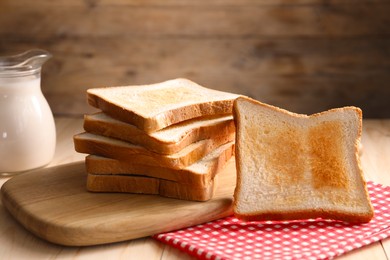 Photo of Slices of tasty toasted bread on wooden table, closeup