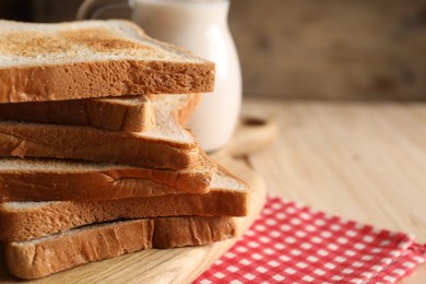 Photo of Slices of tasty toasted bread on wooden table, closeup. Space for text