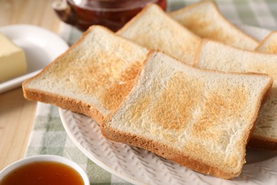 Photo of Slices of tasty toasted bread and jam on wooden table, closeup