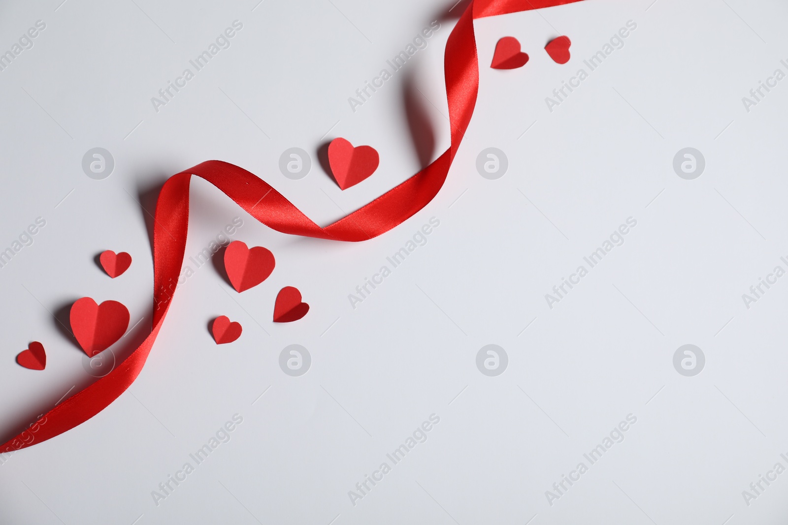 Many paper hearts and ribbon on light grey background, flat lay. Space for text Photo of Many paper hearts and ribbon on light grey background, flat lay. Space for text