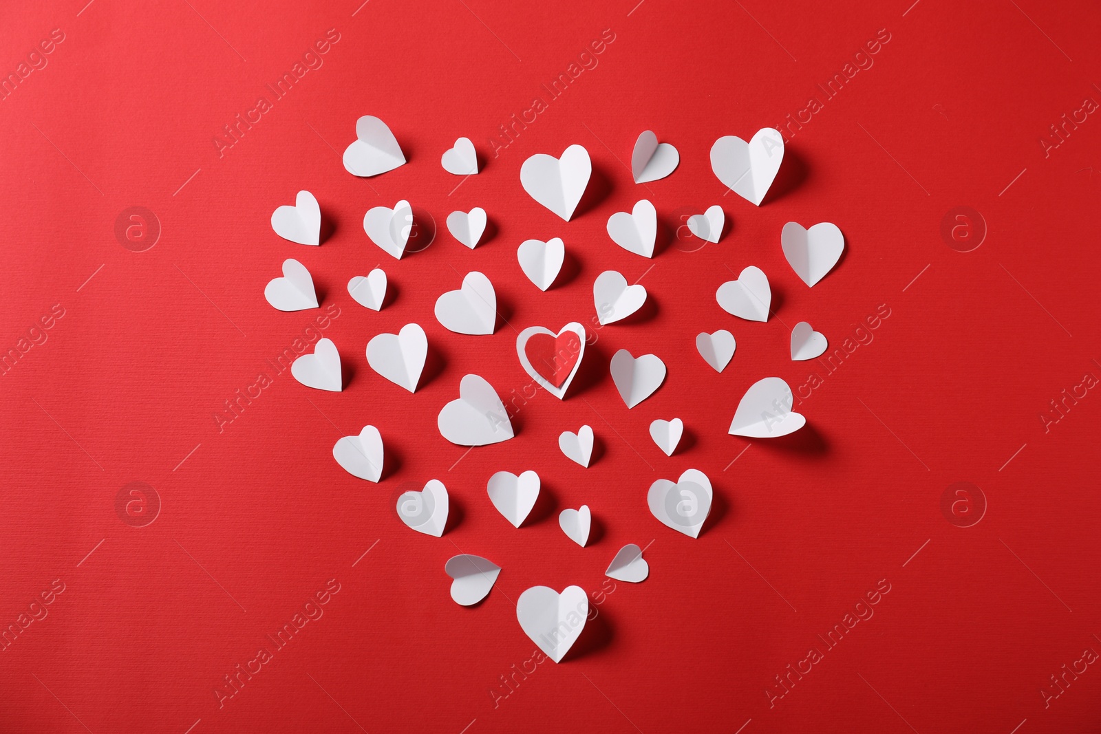 Heart of paper ones on red background, flat lay Photo of Heart of paper ones on red background, flat lay