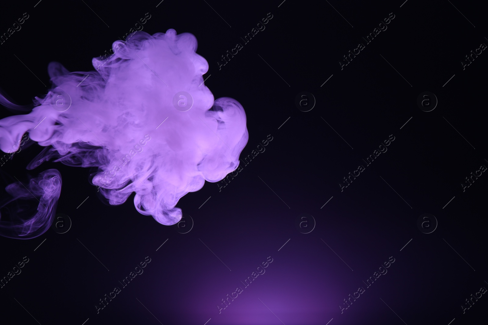 Beautiful smoke in purple light on dark background, space for text Photo of Beautiful smoke in purple light on dark background, space for text