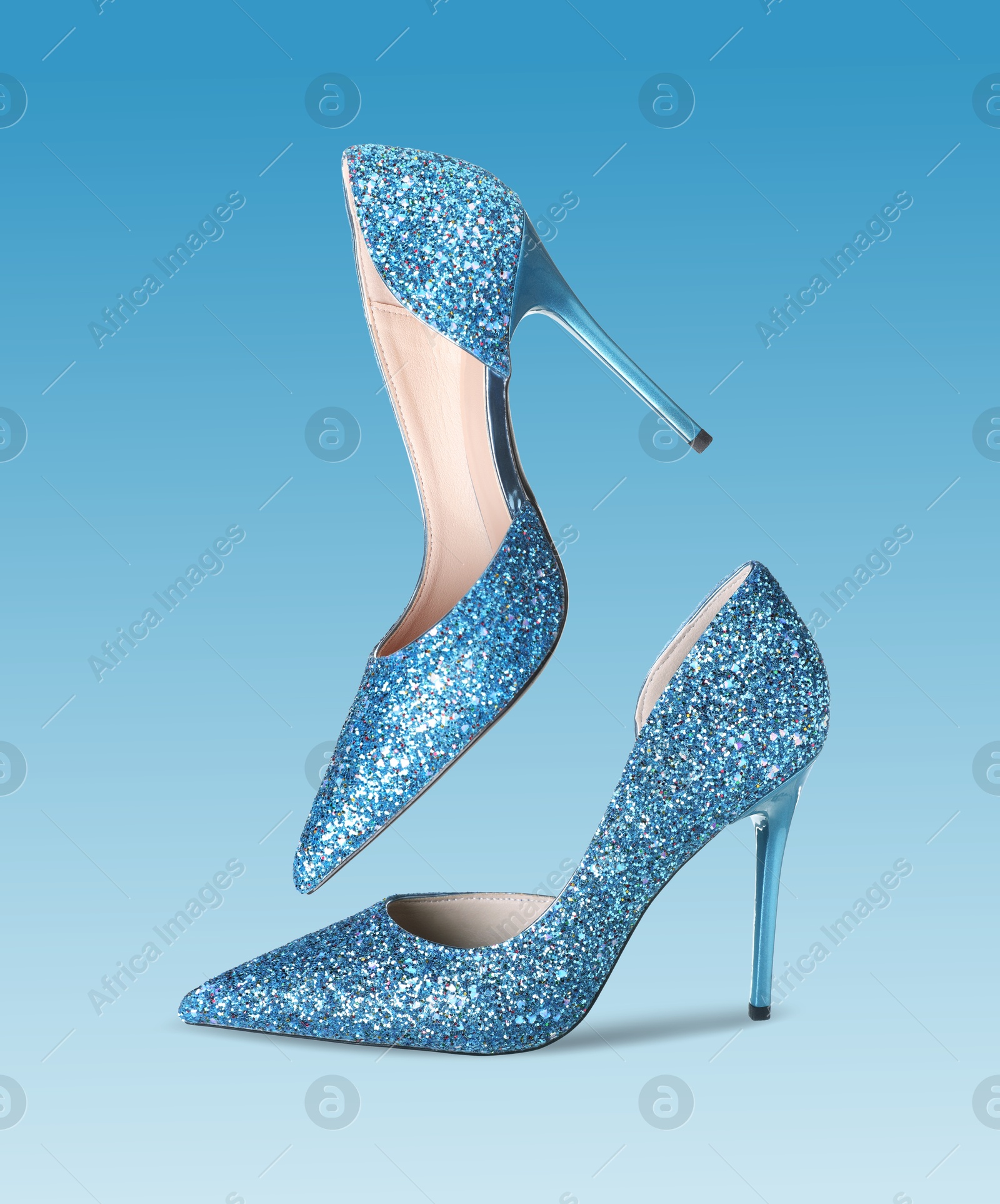 Stylish sparkly high heel shoes in air on blue gradient background Image of Stylish sparkly high heel shoes in air on blue gradient background