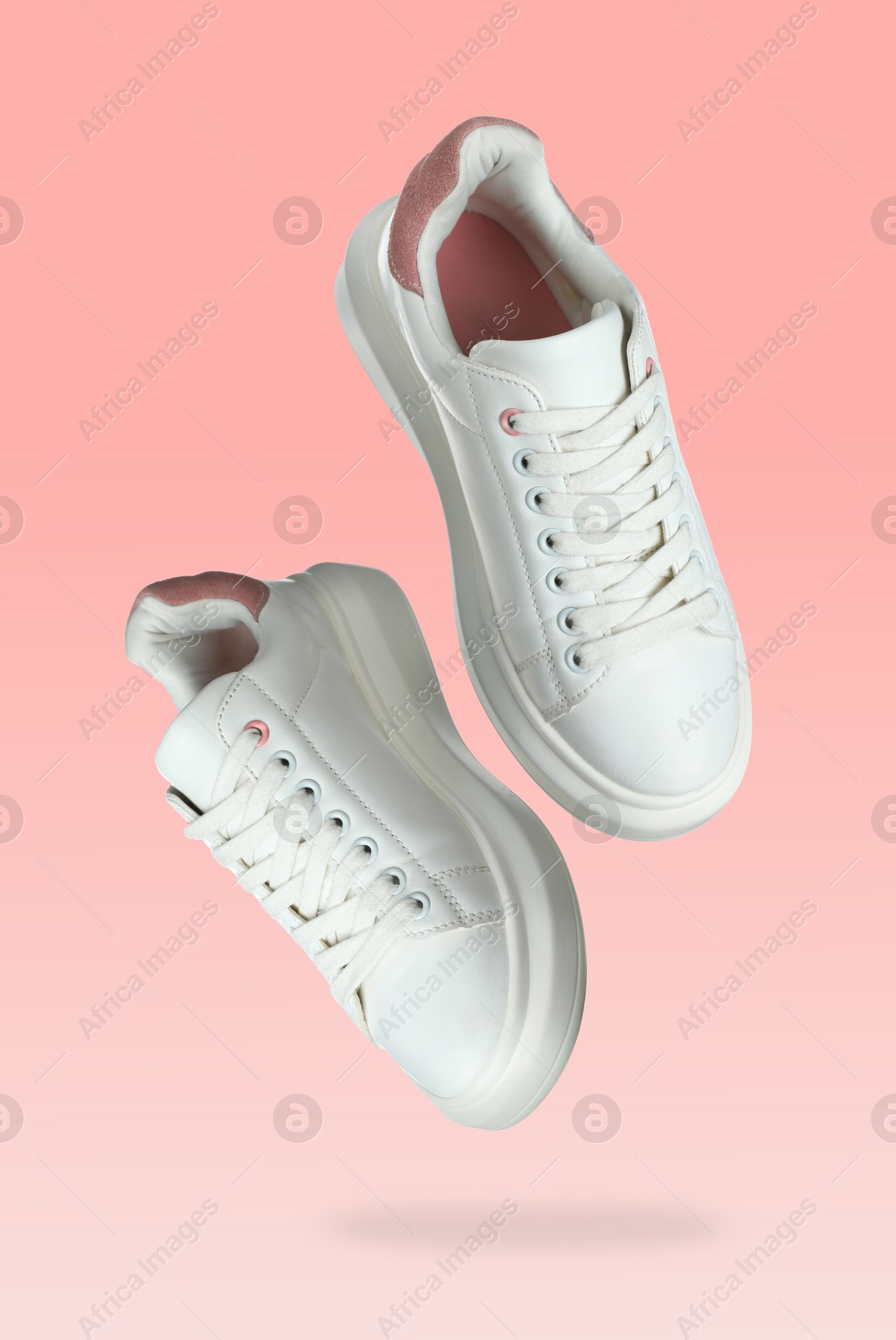 Stylish sneakers in air on pink gradient background Image of Stylish sneakers in air on pink gradient background
