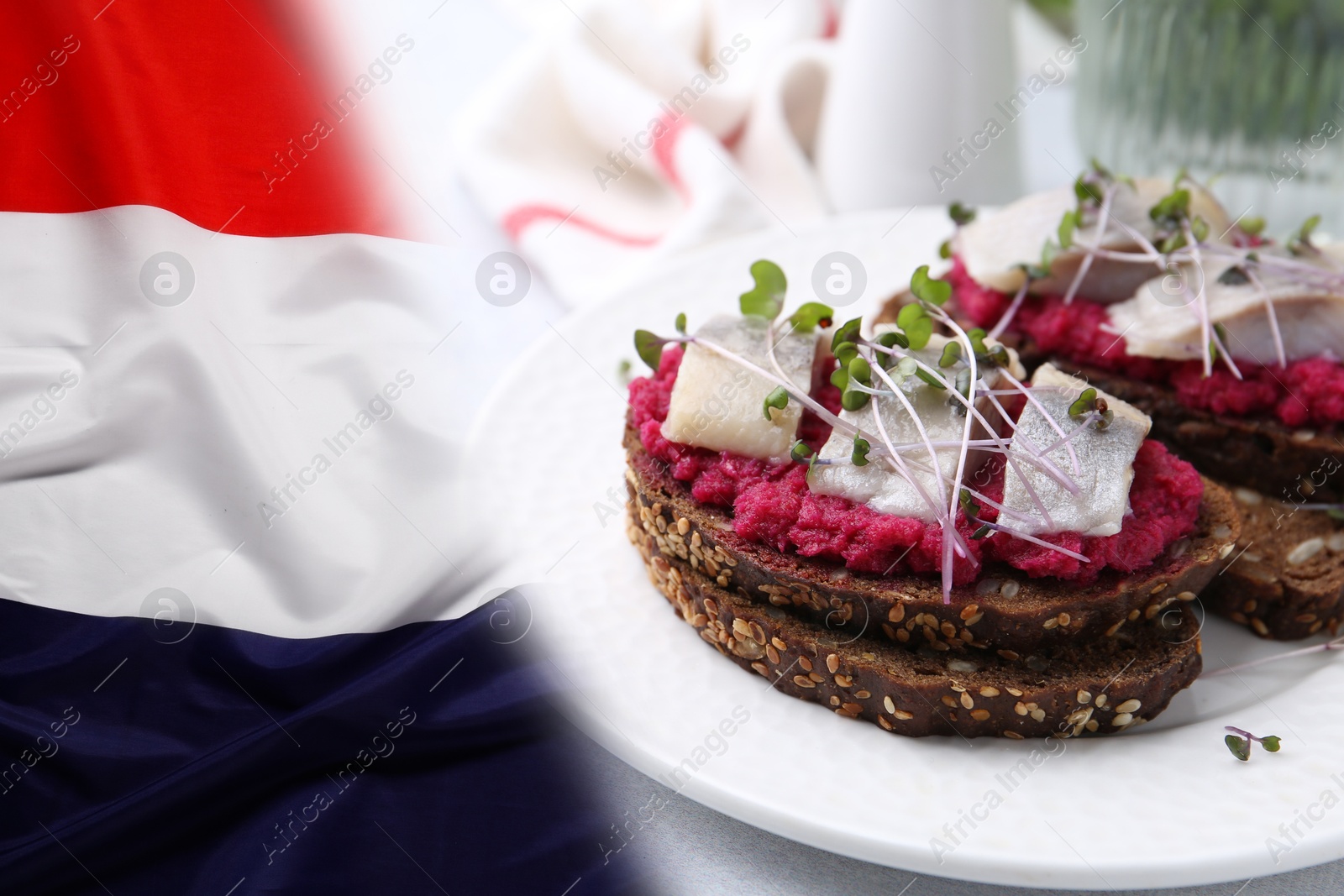 Tasty sandwiches with herring on wooden table and flag of Netherlands Image of Tasty sandwiches with herring on wooden table and flag of Netherlands