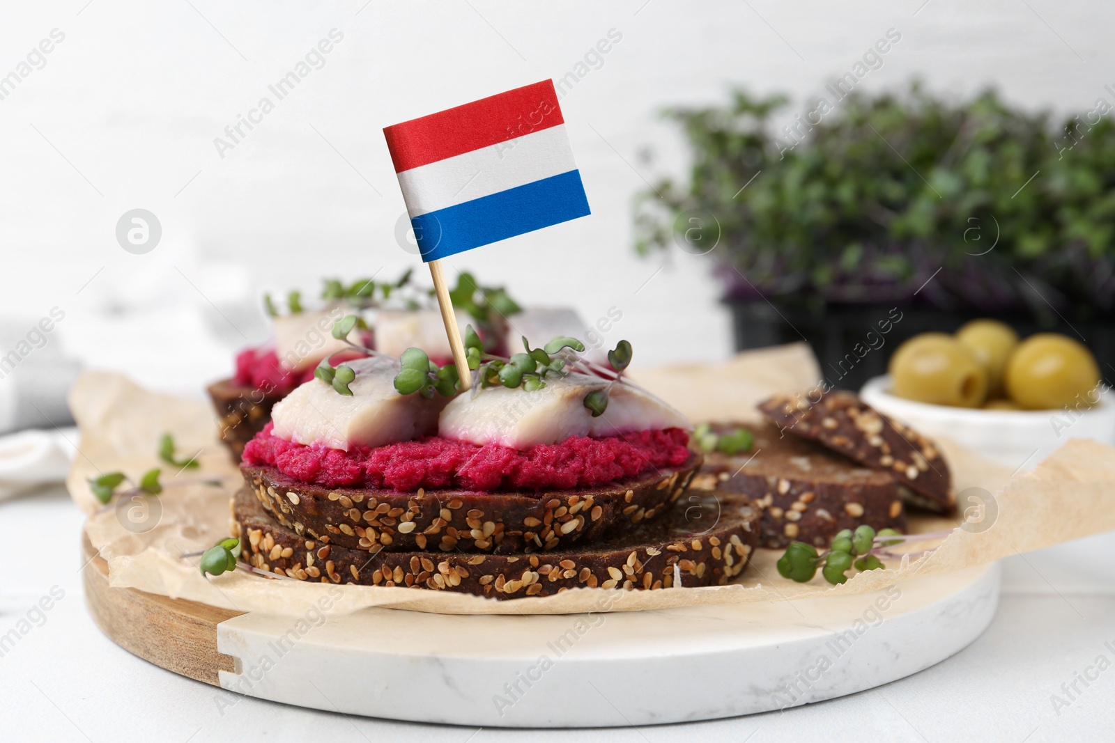 Tasty sandwich with herring and flag of Netherlands on white table Image of Tasty sandwich with herring and flag of Netherlands on white table