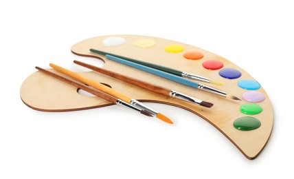 Photo of Wooden palette with paints and brushes isolated on white