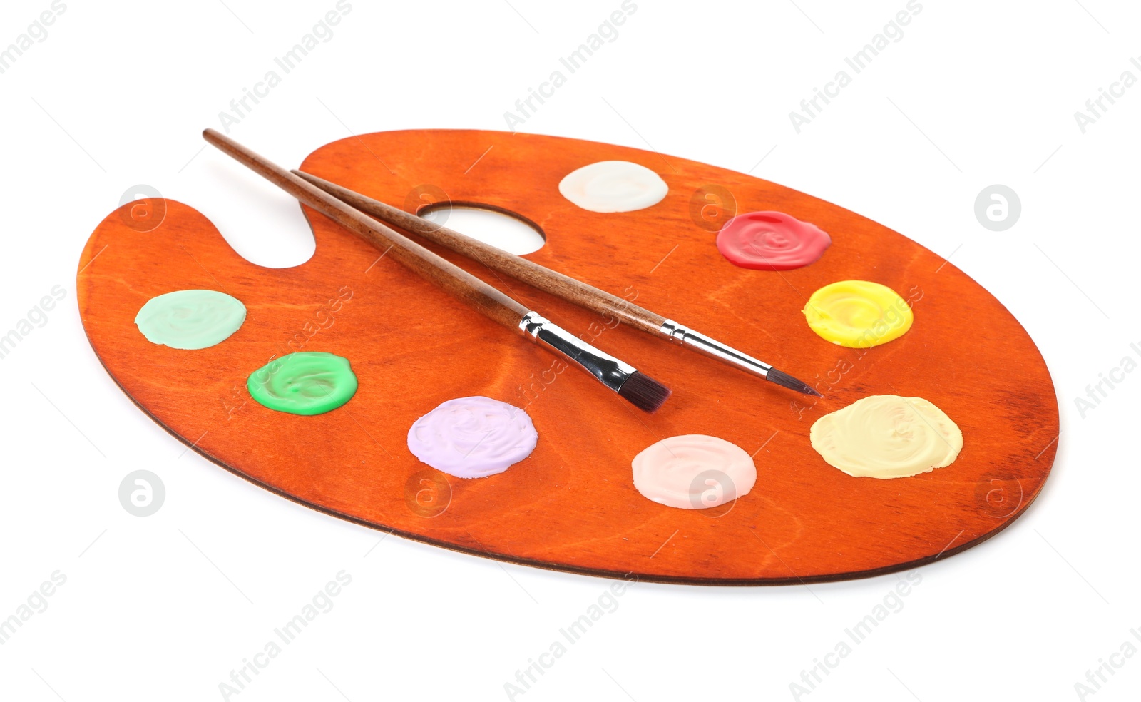 Photo of Wooden palette with paints and brushes isolated on white