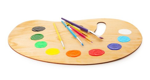 Photo of Wooden palette with paints and brushes isolated on white