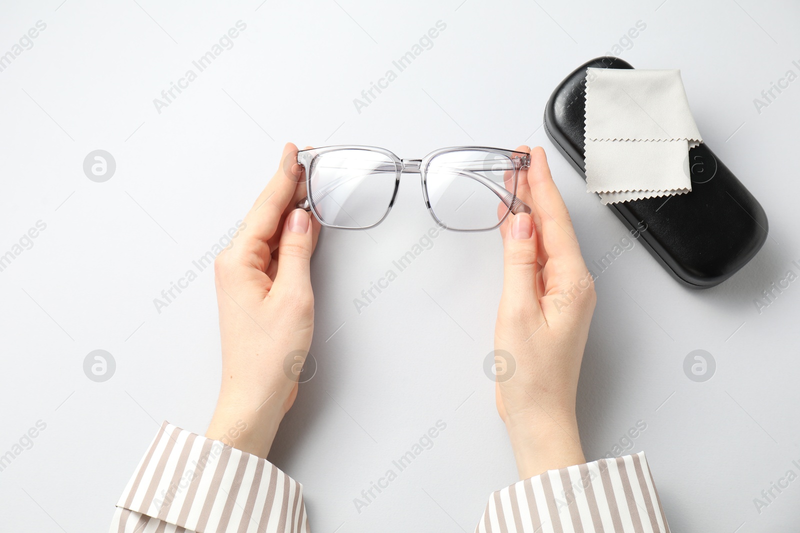 Woman with glasses and case on light background, top view Photo of Woman with glasses and case on light background, top view