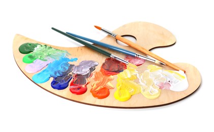 Photo of Wooden palette with paints and brushes isolated on white