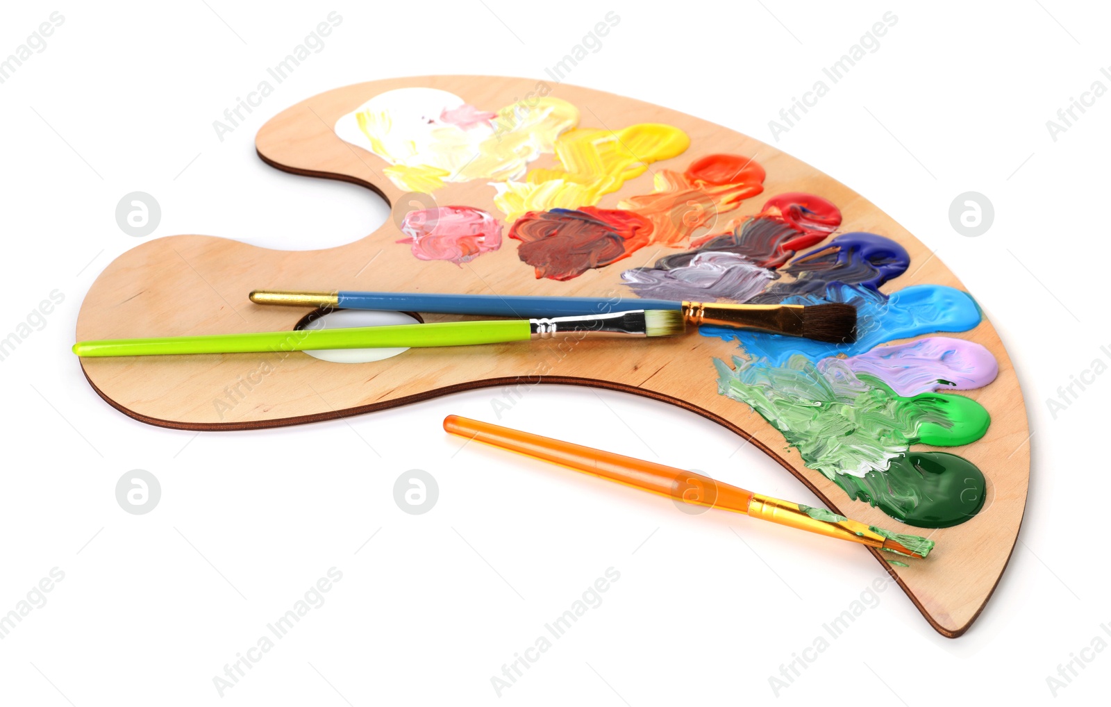 Photo of Wooden palette with paints and brushes isolated on white