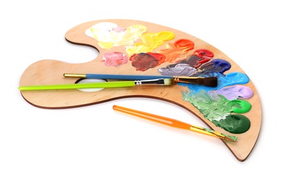 Photo of Wooden palette with paints and brushes isolated on white