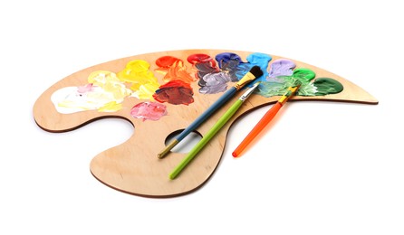 Photo of Wooden palette with paints and brushes isolated on white