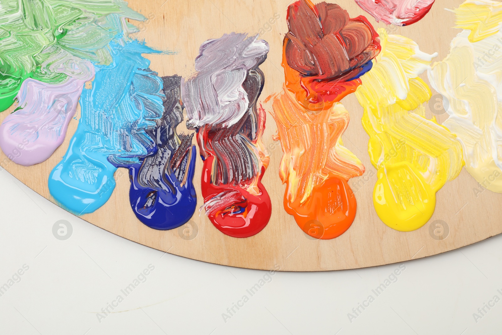 Wooden palette with paints on white background, top view Photo of Wooden palette with paints on white background, top view
