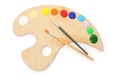 Photo of Wooden palette with paints and brushes isolated on white, top view