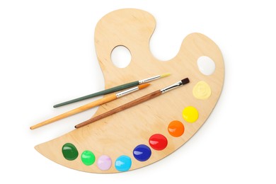 Photo of Wooden palette with paints and brushes isolated on white, top view