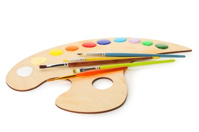 Photo of Wooden palette with paints and brushes isolated on white
