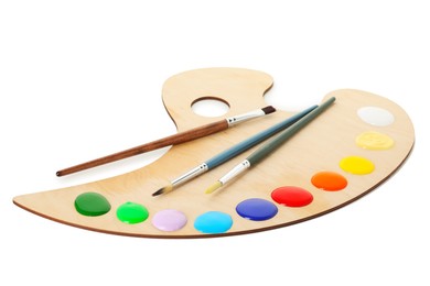 Photo of Wooden palette with paints and brushes isolated on white
