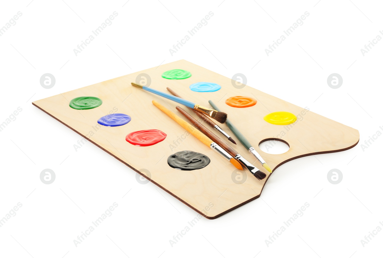 Wooden palette with paints and brushes isolated on white Photo of Wooden palette with paints and brushes isolated on white