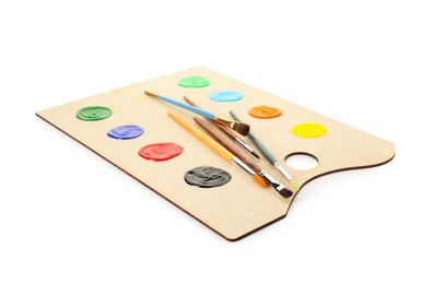 Photo of Wooden palette with paints and brushes isolated on white