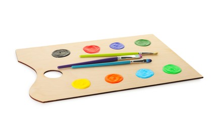 Photo of Wooden palette with paints and brushes isolated on white