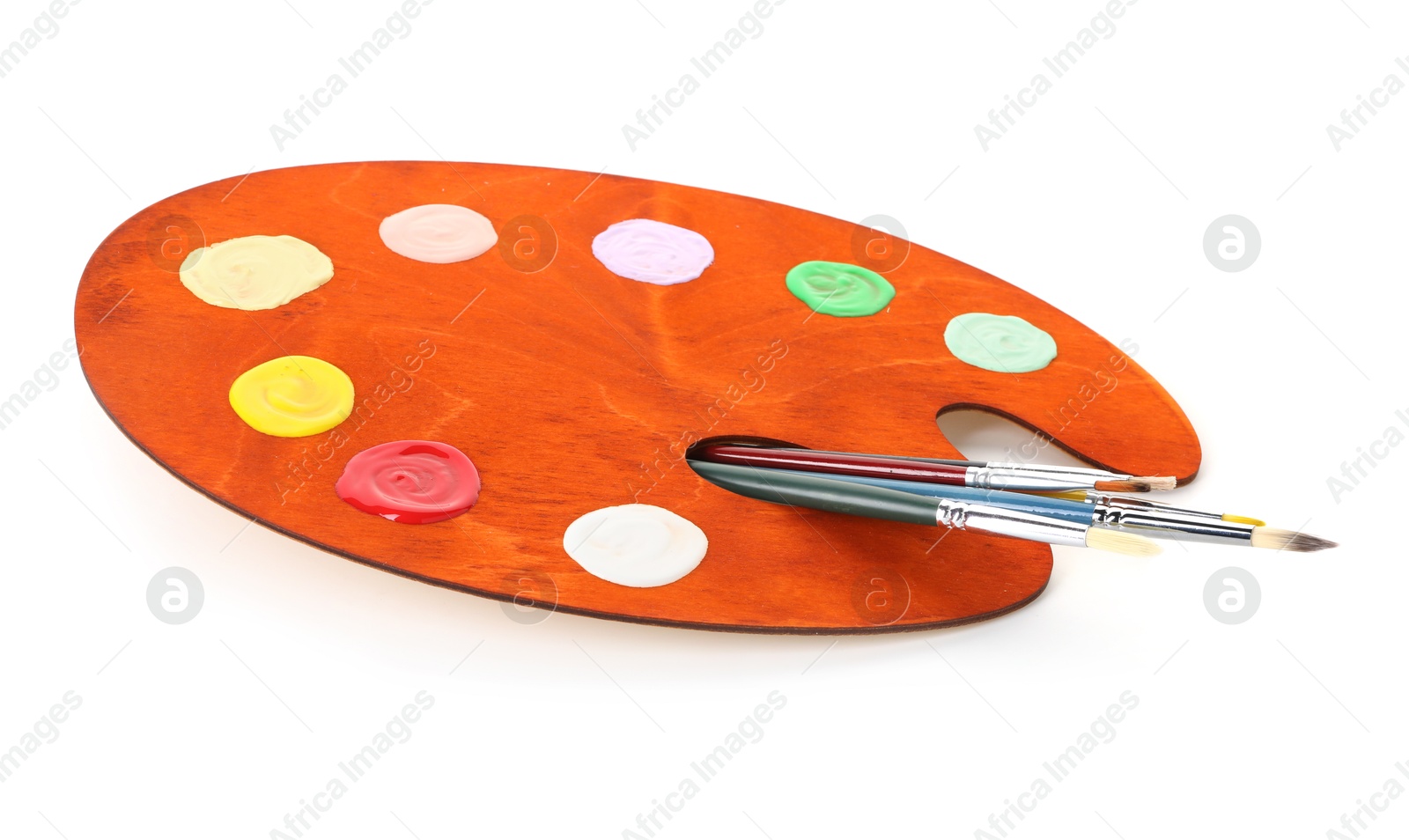 Photo of Wooden palette with paints and brushes isolated on white