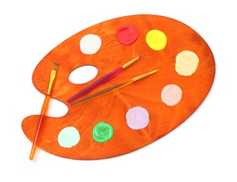 Photo of Wooden palette with paints and brushes isolated on white, top view