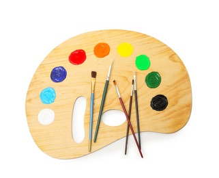 Photo of Wooden palette with paints and brushes isolated on white, top view