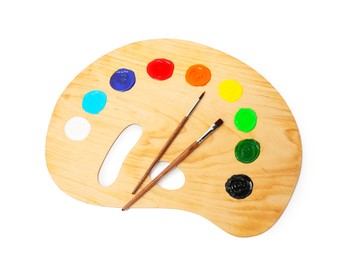 Photo of Wooden palette with paints and brushes isolated on white, top view