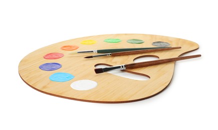 Photo of Wooden palette with paints and brushes isolated on white