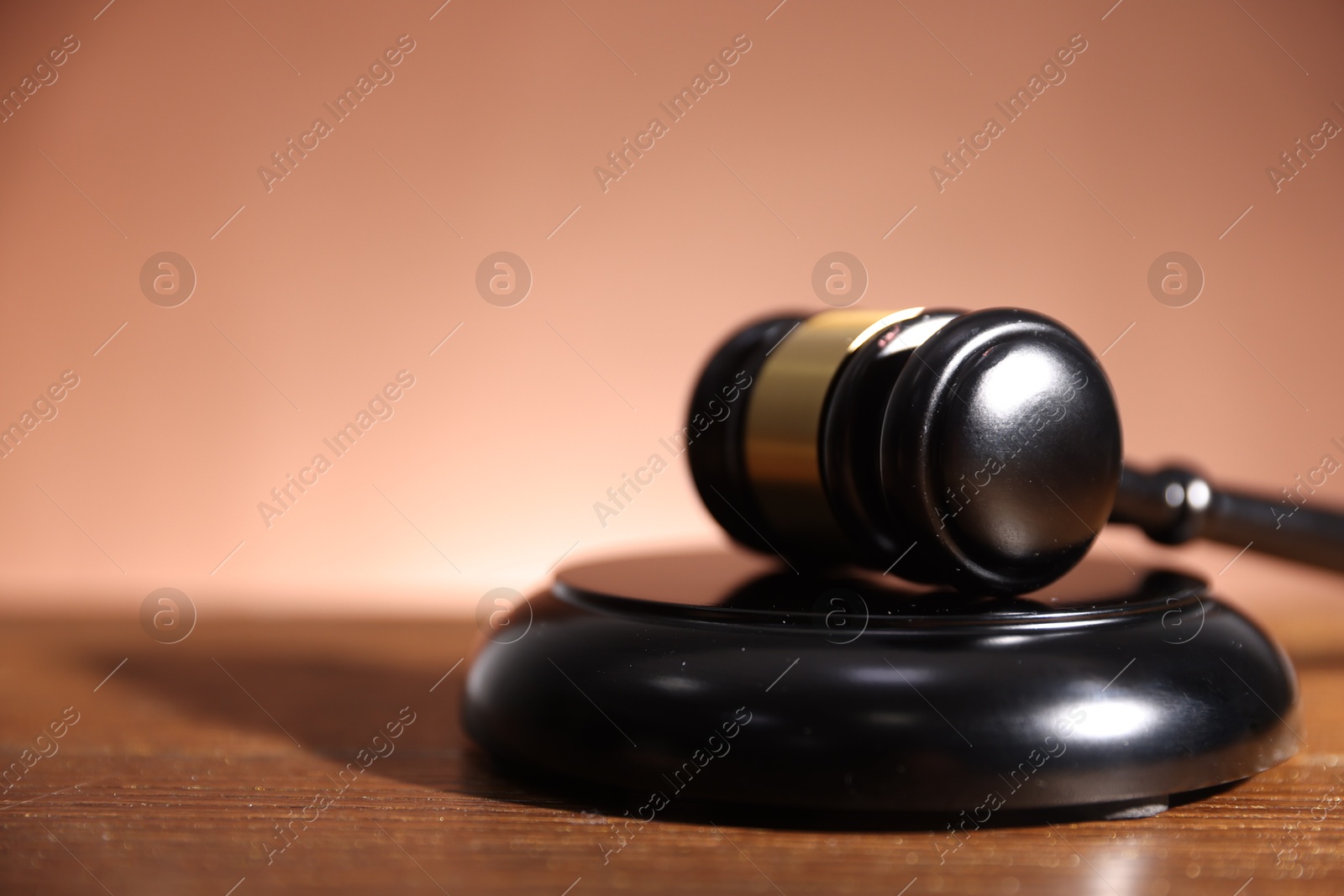 Judge's gavel and sound block on wooden table against pale brown background, closeup. Space for text Photo of Judge's gavel and sound block on wooden table against pale brown background, closeup. Space for text