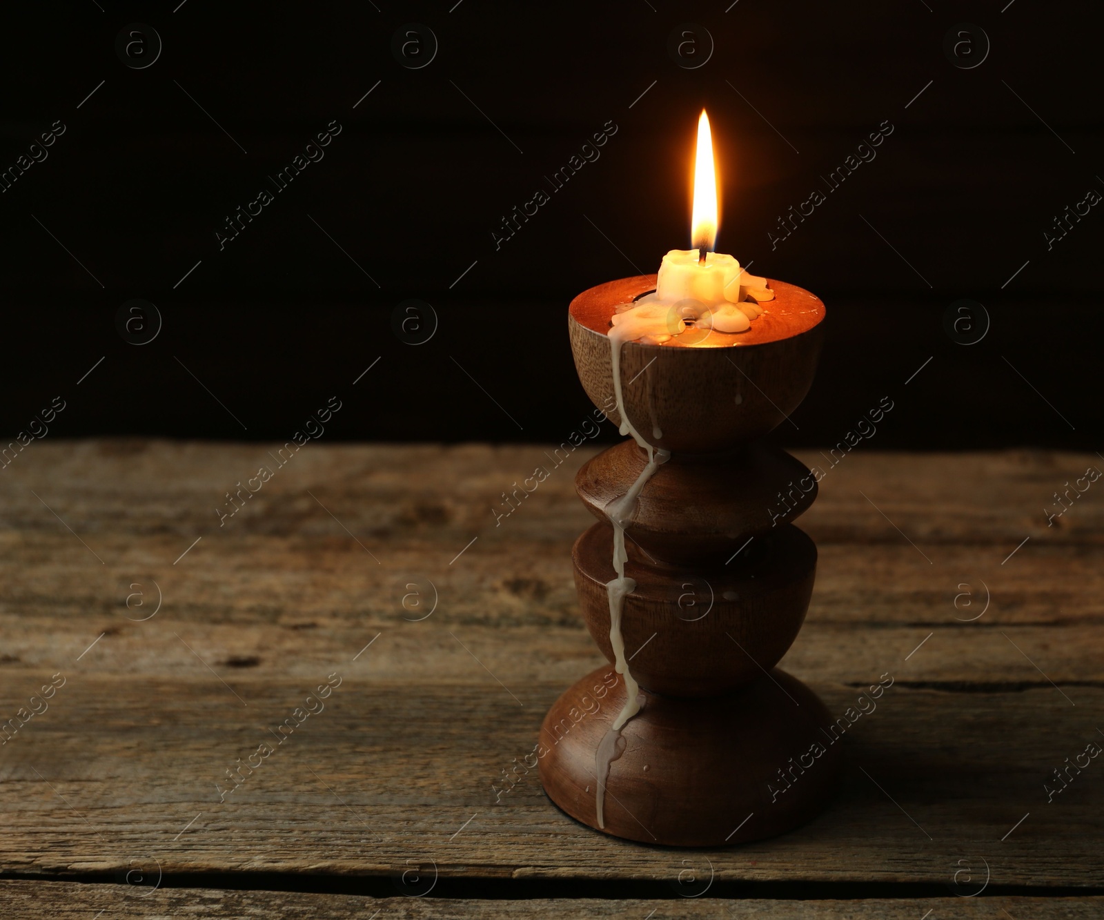 Burning candle in candlestick on wooden table, space for text Photo of Burning candle in candlestick on wooden table, space for text