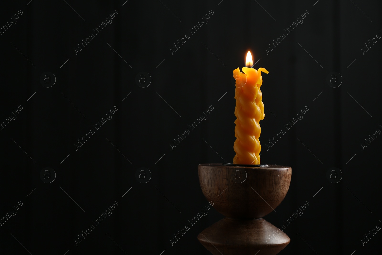 Burning candle in candlestick on mirror surface, space for text Photo of Burning candle in candlestick on mirror surface, space for text