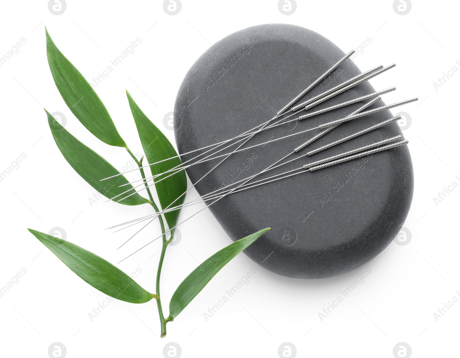 Acupuncture needles, spa stone and leaves isolated on white, top view Photo of Acupuncture needles, spa stone and leaves isolated on white, top view